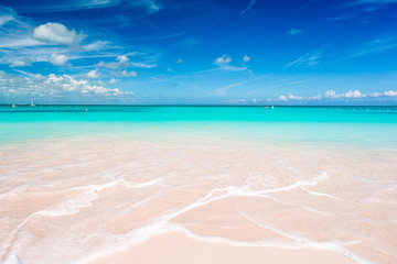 Idyllic tropical beach in Caribbean with white sand, turquoise ocean water and blue sky