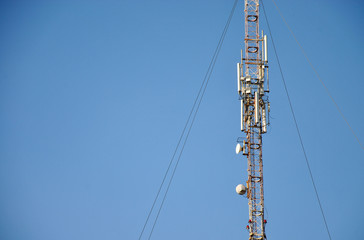 
mobile communications tower on a background of blue sky and place for text