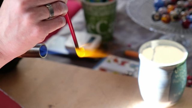 H&auml;nde der Glasbl&auml;serin formen Glasperlen aus Glasst&auml;ben