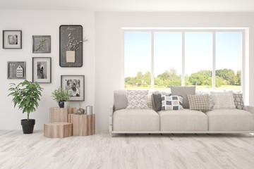 White living room with sofa and summer landscape in window. Scandinavian interior design. 3D illustration