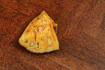 Sweet fresh ripe tasty sliced jack fruit isolated on wooden background