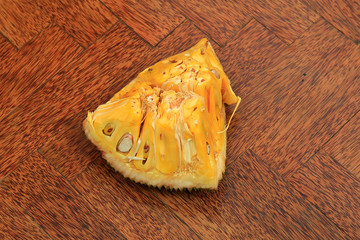 Sweet fresh ripe tasty sliced jack fruit isolated on wooden background