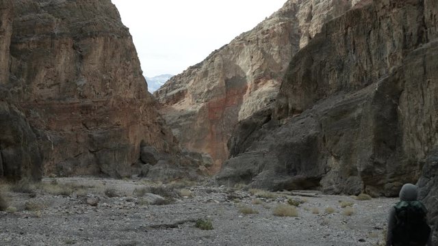 A male hiker walks through Fall Canyon in Death Valley National Park in California.