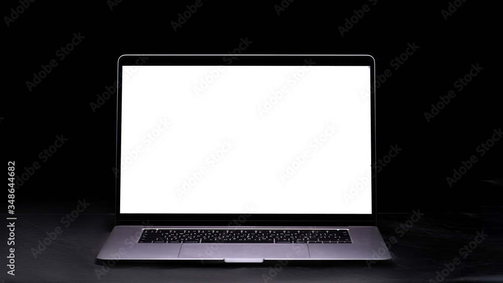 Wall mural computer with blank screen on the table on a black background. mockup and space for text and adverti