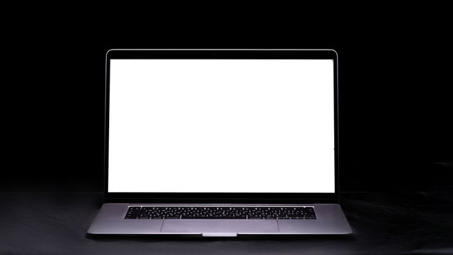 Computer with blank screen on the table on a black background. Mockup and space for text and advertising. Copy space - Powered by Adobe