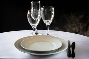 primer plano de mesa con platos cuchillo tenedro copas y luces led 