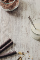 Chocolate waffles, cocoa powde and a glass of milk on a rustic wooden background, as a breakfast or sweet dessert, selective focus