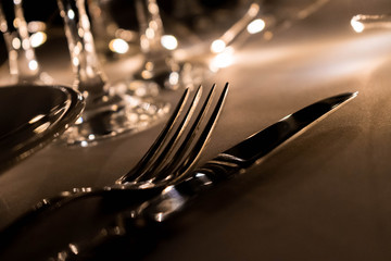 primer plano de mesa con platos cuchillo tenedro copas y luces led 