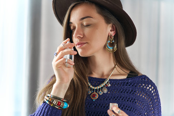 Stylish fashionable attractive brunette gypsy boho chic woman with closed eyes wearing jewelry and...