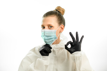 young blonde woman in protective suit and gloves shows ok sign
