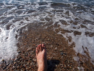 Bare feet in the mediterranean sea. Spain.