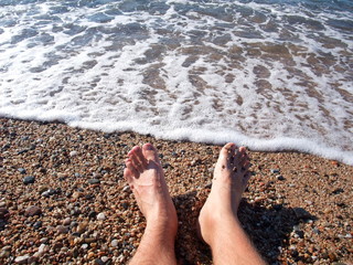 Bare feet in the mediterranean sea. Spain.
