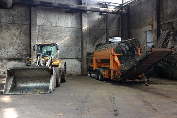 Fototapeta na wymiar Wheel loader and drum screen in a composting facility for biowaste, green waste and sewage sludge. 