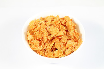 close up of muesli with dried fruits and yogurt in bowl on white background