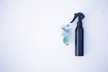 Brown spray bottle with green eucalyptus branch on the bright background