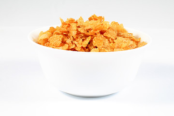 close up of muesli with dried fruits and yogurt in bowl on white background