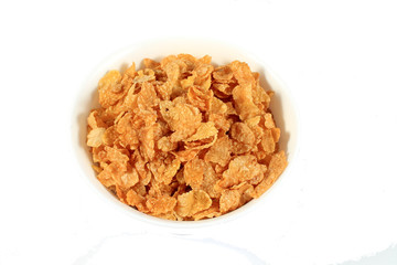 close up of muesli with dried fruits and yogurt in bowl on white background
