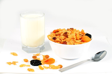 close up of muesli with dried fruits and yogurt in bowl on white background