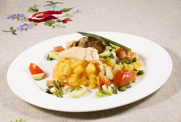 close up of potato with chicken with vegetables and salad on plate