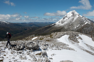 Naklejka na ściany i meble Montañero realizando una ruta con vistas al fondo del pico Espigüete, con una altitud de 2450 m, en el Parque Natural Montaña Palentina, en la cordillera Cantábrica. 