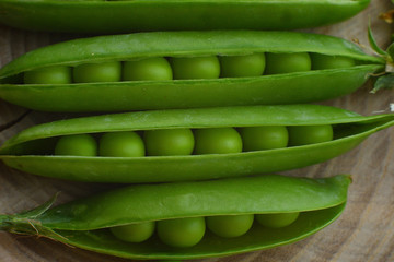 New harvest of fresh ripe green peas. legumes.Green peas and pea pods on wooden background.Close-up