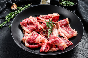 Strips of marbled beef, quick steak. Black background. Top view