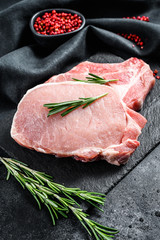 Raw pork chop steak. Organic meat. Black background. Top view