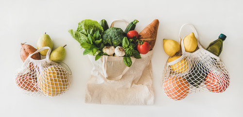 Online grocery healthy shopping. Flat-lay of fruit, vegetables, greens, bread and oil in eco-friendly bag over white background, top view. Shop online during pandemic of coronavirus banner for website