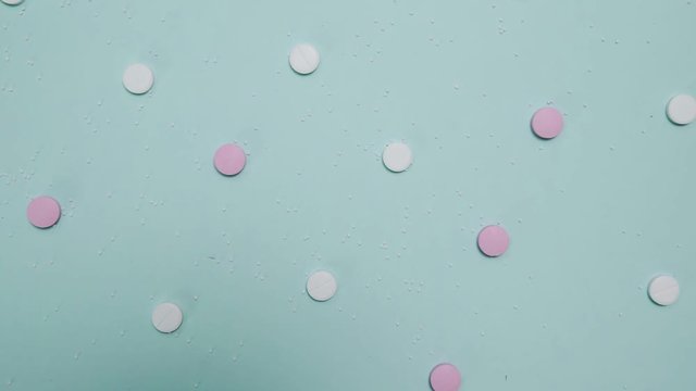 Pink and white pills on blue background