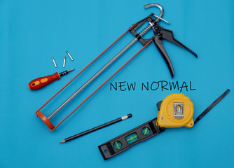 "New Normal" on masks and tools with blue background, New Normal concept.