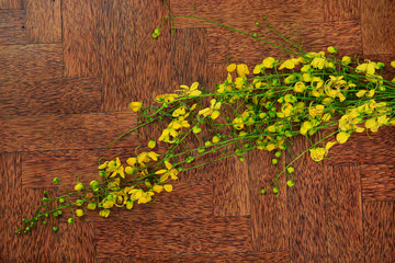 Golden shower flower (kanikonna) isolated on wooden background