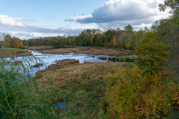 Fototapeta na wymiar View of the Rumba waterfall in Kuldiga in the fall. Colorful leaves. Beautiful landscape in Latvia.