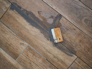 Grouting between ceramic tiles. Work tool spatula. Repair in the room