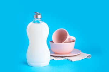 Clean washed tableware. Concept of washing dishes. Dishwashing liquid with plates and cups on blue background...