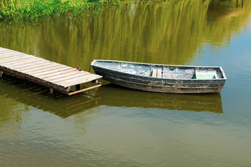 Obraz premium An old wooden boat in the river near