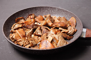 Side view of fried mushrooms in a pan