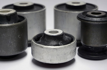 New original high-quality parts of a modern car, spare parts for suspension repair. A group of bonded rubber mounts are isolated on a white background.