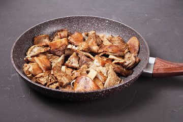 Side view of fried mushrooms in a pan