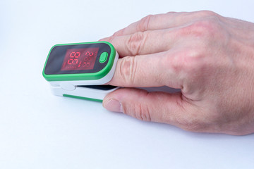 Close-up of a hand wearing a pulse oximeter to measure blood oxygen saturation. Diagnostic concept COVID-19