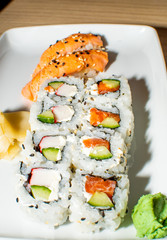 A selection of sushi rolls with salmon, tuna, cucumber and soy sauce dip.