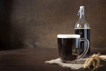 Russian beverage fermented kvass from rye bread in half-liter mug on dark. Close up.