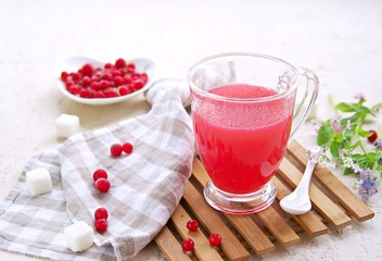 Traditional Russian hot drink red currant jelly or kissel in a transparent glass cup on a light concrete background. Drink recipes. Berry drinks.