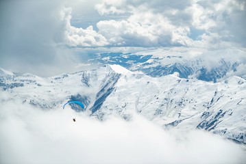 Fototapeta na wymiar Paragliding in Gudauri ski resort winter. Caucasus mountains in Georgia