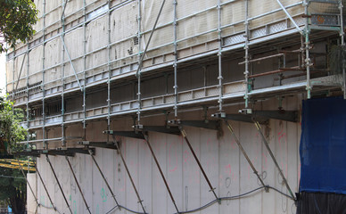 Canterlevered steel scaffolding work platforms with netting on a new muti story apartment building...