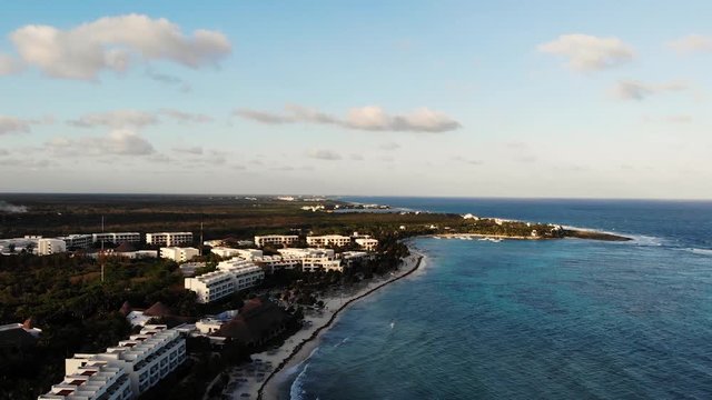 Aerial footage of the ocean and the beach in the Akumal Bay in Quintana Roo, Mexico during Sunset