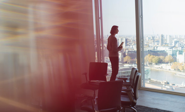 Thoughtful businessman standing at highrise office window