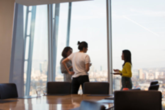 Business people talking at highrise conference room window