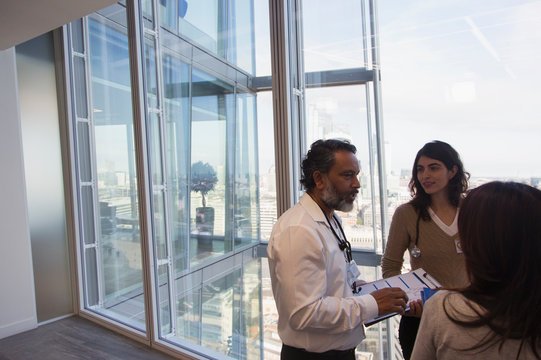 Business people talking at urban highrise office window