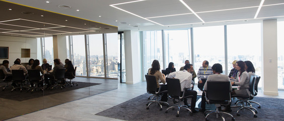 Business people talking in circle in conference room meeting