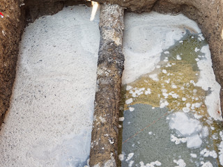 Repair and replacement of water pipes in the pit. Old pipe and water in the pit. Accident, blackout.